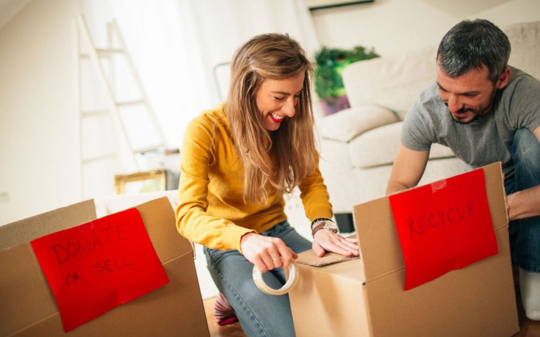 Smiling couple busy packing boxes before a house move