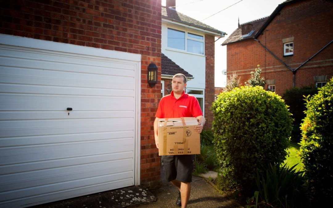 Britannia Alan Cook Removals team carrying a loaded box to the removals lorry