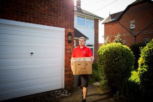 Britannia Alan Cook Removals team carrying a loaded box to the removals lorry